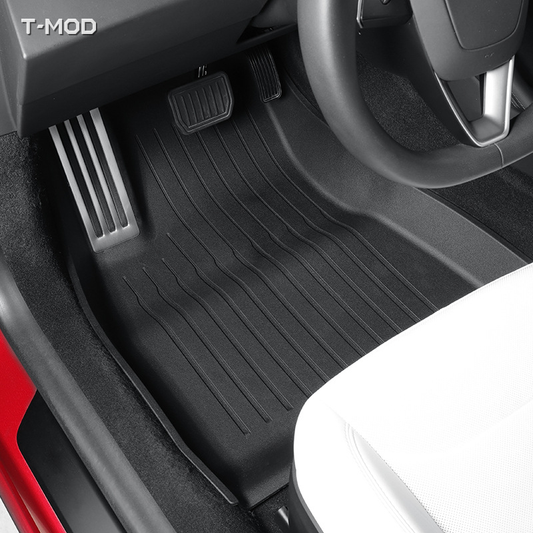 Driver-side black floor mat with silver aluminum pedal plate in a Tesla Model 3 Highland