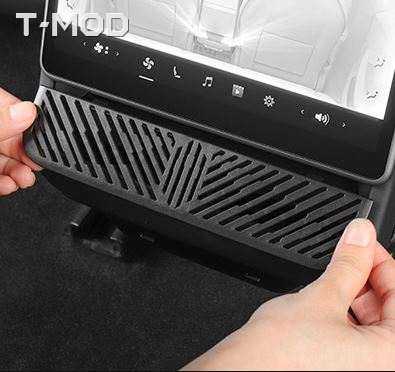 Black ABS rear air vent grille cover being installed in a Tesla Model 3 Highland
