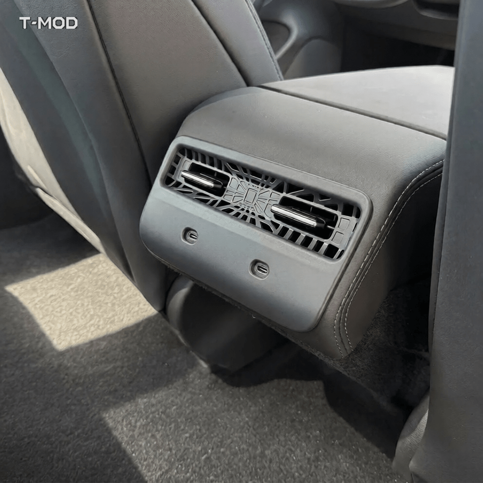 Silver gray matte rear air vent protection grid installed in a Tesla Model Y Standard cabin